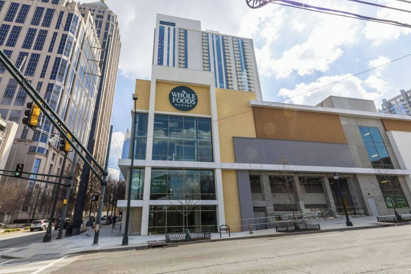 Edificio Whole Foods Market con facciata in vetro moderna, situato in zona urbana con alti edifici circostanti.