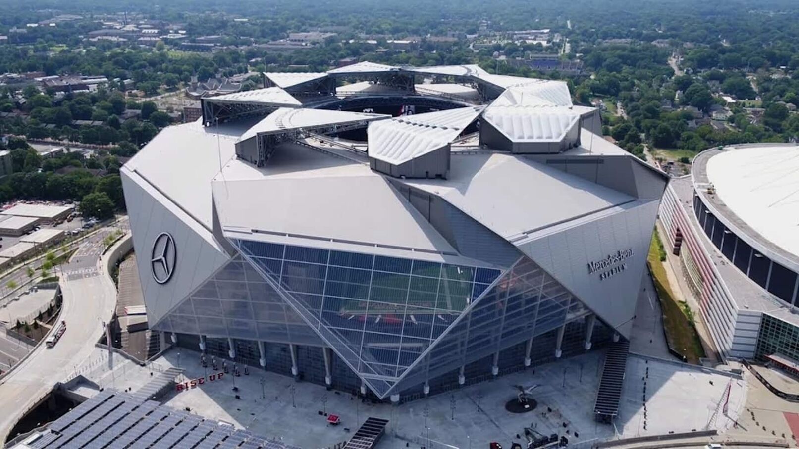 Un stade moderne doté d’un toit aux lignes angulaires distinctives et du logo Mercedes-Benz.