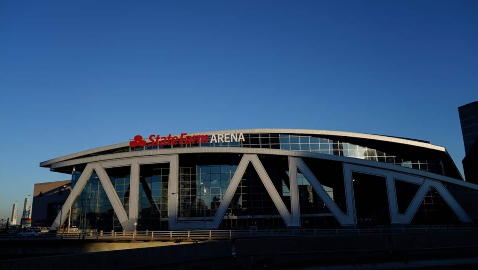 A modern stadium with a curved roof and large glass windows.