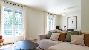 Un salon moderne avec un canapé, une table basse ronde et une suspension.