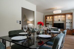 A modern dining area with a glass table set for four, surrounded by upholstered chairs. - By the canal - Pets allowed - 3 bedrooms and an enclosed garden (Aÿ-Champagne)