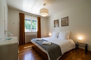A bedroom with a bed, bedside tables, a radiator, a window with curtains, and a ceiling light fixture. - By the canal - Pets allowed - 3 bedrooms and an enclosed garden (Aÿ-Champagne)