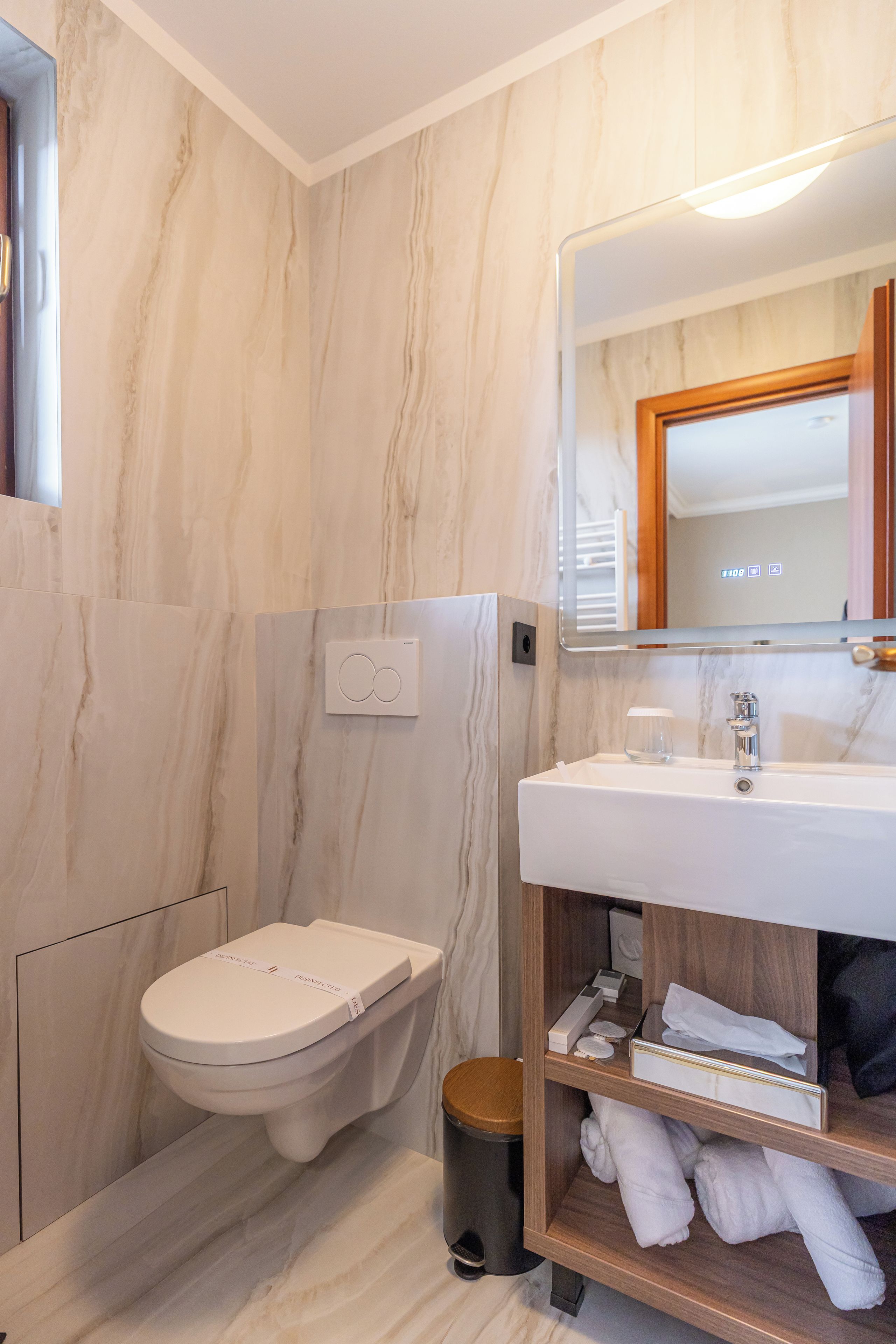 A modern bathroom with a toilet, a sink, and a mirror.