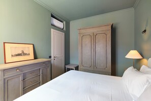 A bedroom with a bed, a dresser, a wardrobe, a framed picture on the dresser, and a bedside lamp. - Luxury and Design in the Center of Milan, Stazione Garibaldi Brera (Milano)