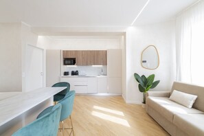 A modern apartment with a kitchen, dining area, and living room.