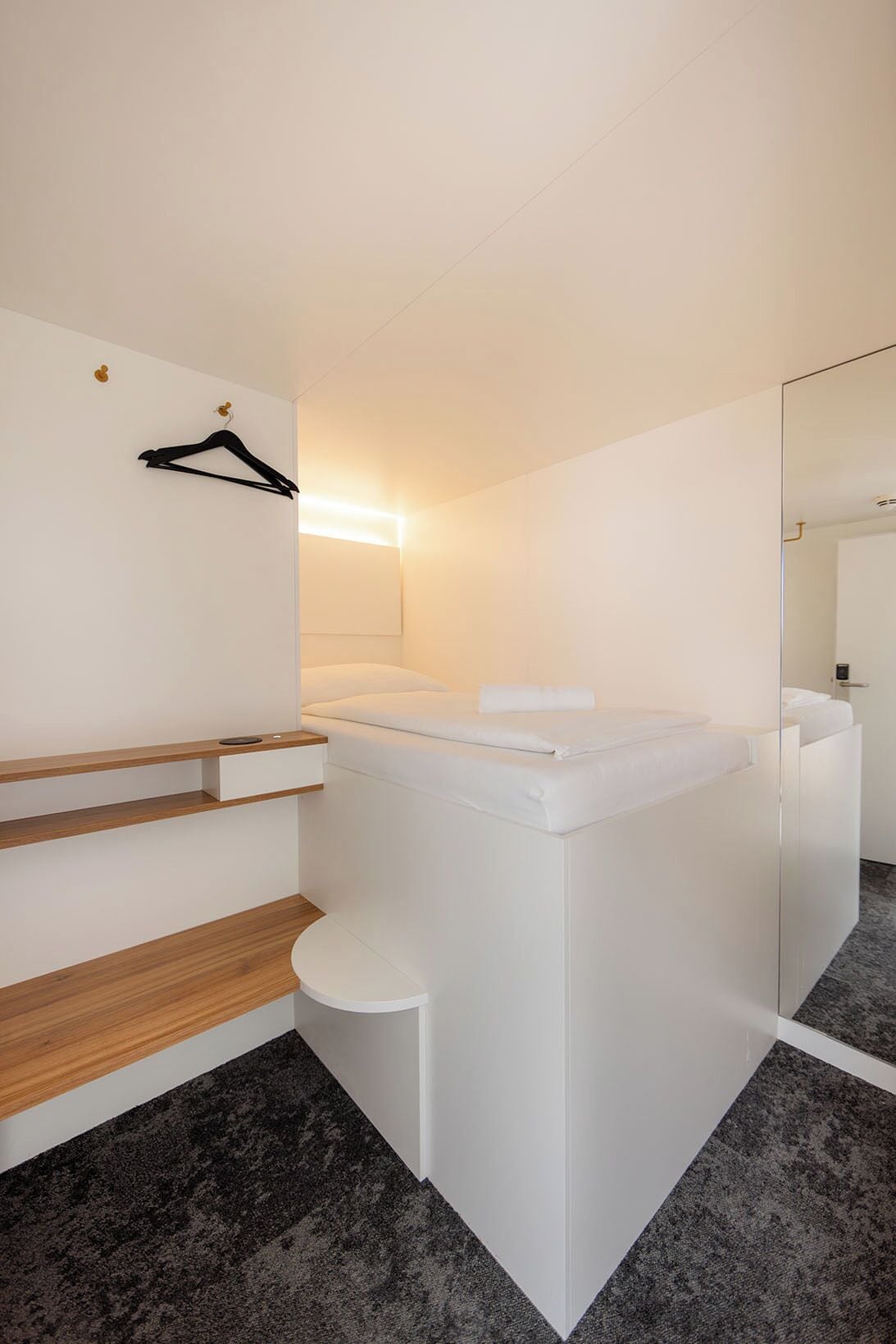 Ein modernes Badezimmer mit einem weißen Waschtisch, einem Spiegel und einem Handtuchhalter.
