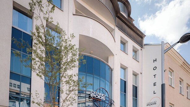 A hotel with a modern facade, large windows, and a visible entrance. - Grand Pods  (Vienna)