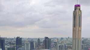 Una piscina en la azotea con sillones de descanso y vista panorámica de la ciudad.