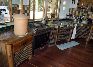 A kitchen with a wooden countertop, a stove, and a sink. - Paradiselodge - Poolvilla - next to Nauyaca (Platanillo de Baru)