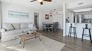 A modern living room with a sofa, coffee table, and dining area.