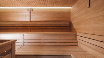 Una sauna con bancos de madera y un banco a la izquierda.