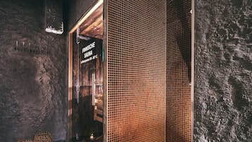 A sauna with a wooden door and a sign indicating a temperature of 90-95°C.