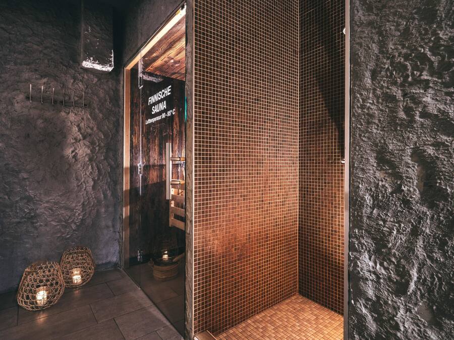 A sauna with a wooden door and a sign indicating a temperature of 90-95°C.