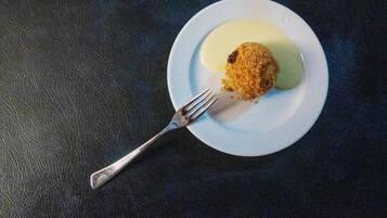 Ein Teller mit einer Speise und einer Gabel auf einer dunklen, strukturierten Oberfläche.