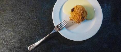 Un plato con comida y un tenedor sobre una superficie oscura y con textura.