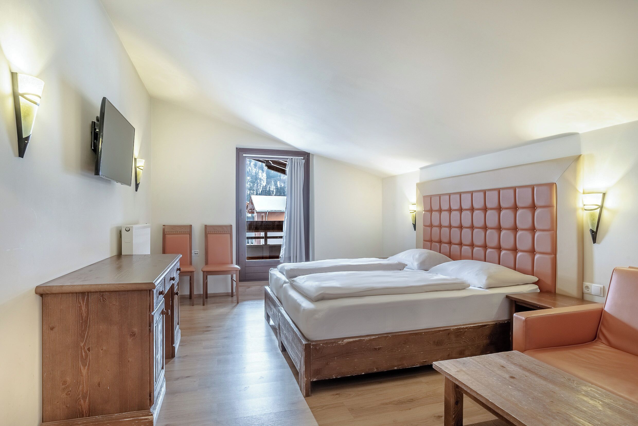 Ein Schlafzimmer mit einem Bett, Nachttischen, einem Schreibtisch und einem Stuhl.