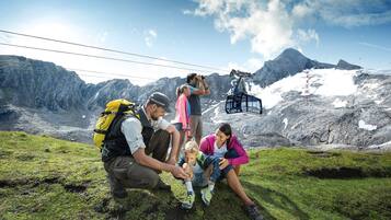 Un grupo de personas en una montaña, con un telesilla al fondo.