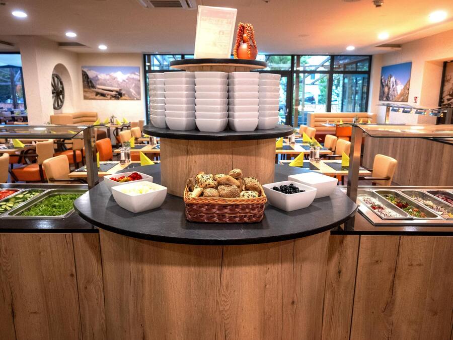 A buffet setup with various food options and a central display of bread baskets.