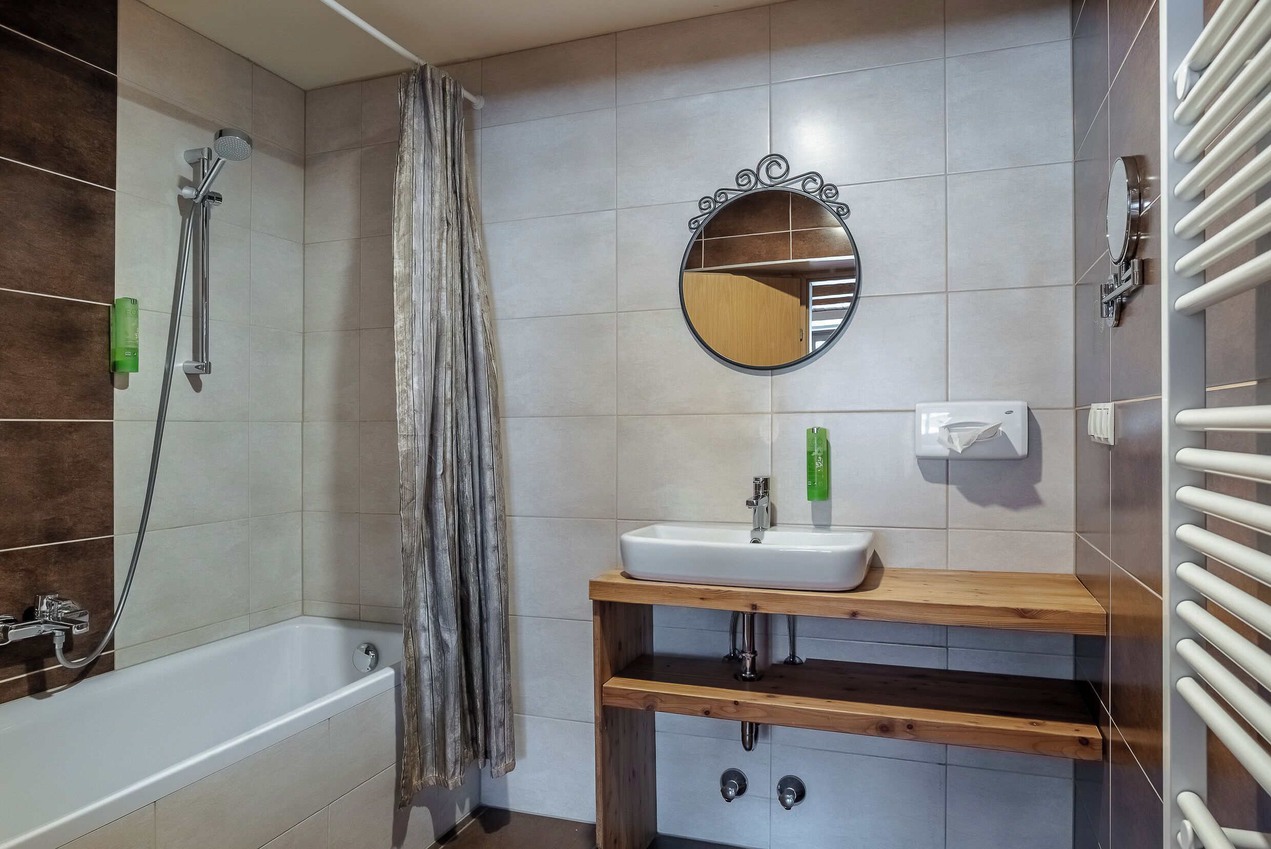 A bathroom with a bathtub, a sink, a mirror, and a shower.