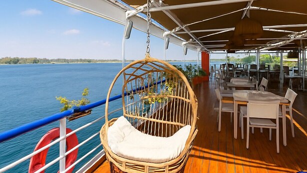 Une terrasse dotée d’une chaise en osier, d’un coin repas et d’une bouée de sauvetage.