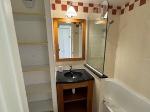 Ein Badezimmer mit Waschbecken, Spiegel und Dusche.