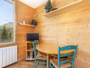A wooden interior with a television on a shelf, a table, and chairs. - Cozy renovated studio for 2 in Avoriaz, view of Hauts Forts (Avoriaz)
