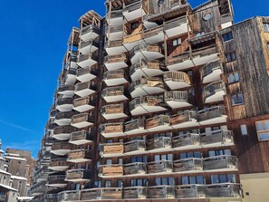 A multi-story building with a unique architectural design featuring balconies on every floor.
