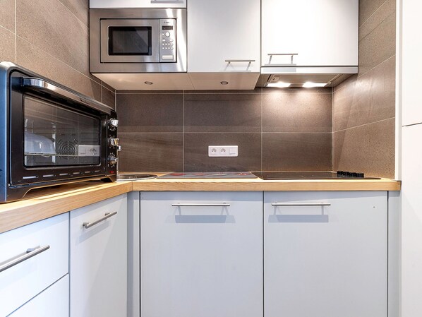 A kitchen with a built-in microwave, a stove, and a sink.