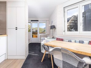Cocina compacta con comedor, ventana con vistas a la montaña y puerta que da a un espacio exterior.