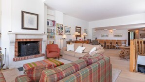A spacious living room with a fireplace, a sofa set, a dining area, and a bookshelf. - Chalet Babayaga, 7 rooms, 12 pers, ski-in/ski-out access (Avoriaz)