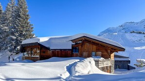 A wooden cabin with a sloped roof, surrounded by snow-covered terrain and a clear blue sky. - Chalet Babayaga, 7 rooms, 12 pers, ski-in/ski-out access (Avoriaz)
