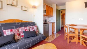 A compact living space with a sofa, a dining table, and a kitchenette. - Studio 4 pax in Avoriaz, quiet with balcony (Avoriaz)