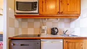 A compact kitchen with a microwave, coffee maker, and dishwasher. - Studio 4 pax in Avoriaz, quiet with balcony (Avoriaz)