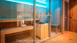 A modern bathroom with glass partitions, wooden shelves, and a wooden floor. - Exceptional loft for 12, ski-in access, sauna & hammam (Avoriaz)