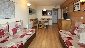 A cozy room with two wooden sofas, a dining table, and a TV. - 3-room apartment, sleeps 6 in Avoriaz (Avoriaz)