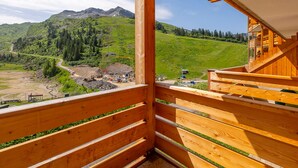 Un balcón de madera con vistas a un paisaje montañoso.