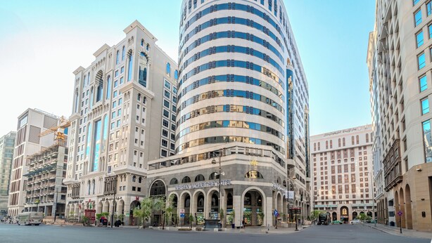 Un hôtel moderne à la façade incurvée, doté d’une entrée en arc de cercle et de plusieurs étages.