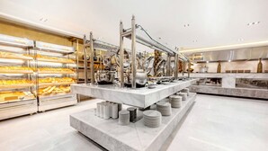 Un buffet composé de plusieurs présentoirs, d’un comptoir en marbre et d’une variété de plats présentés dans des vitrines.
