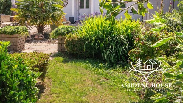 A residential property with a well-maintained garden, a pathway leading to the entrance, and a white house with a green roof. - Deluxe 6 - Single - New Forest (Dibden Purlieu)