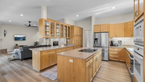 Une cuisine moderne avec des meubles en bois, des appareils en acier inoxydable et un îlot central.