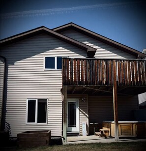 A two-story house with a covered patio area and a small deck. - Harper House-Home away from home in Lethbridge (Lethbridge)