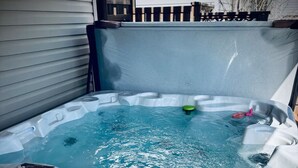A hot tub with a wooden deck and a wooden fence in the background. - Harper House-Home away from home in Lethbridge (Lethbridge)