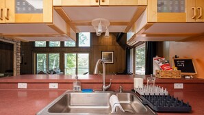 Une cuisine avec des meubles en bois, un évier en acier inoxydable et une pancarte sur laquelle on peut lire : « Bienvenue au bord du lac ».