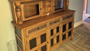 Een houten console tafel met glazen deuren en een spiegel.