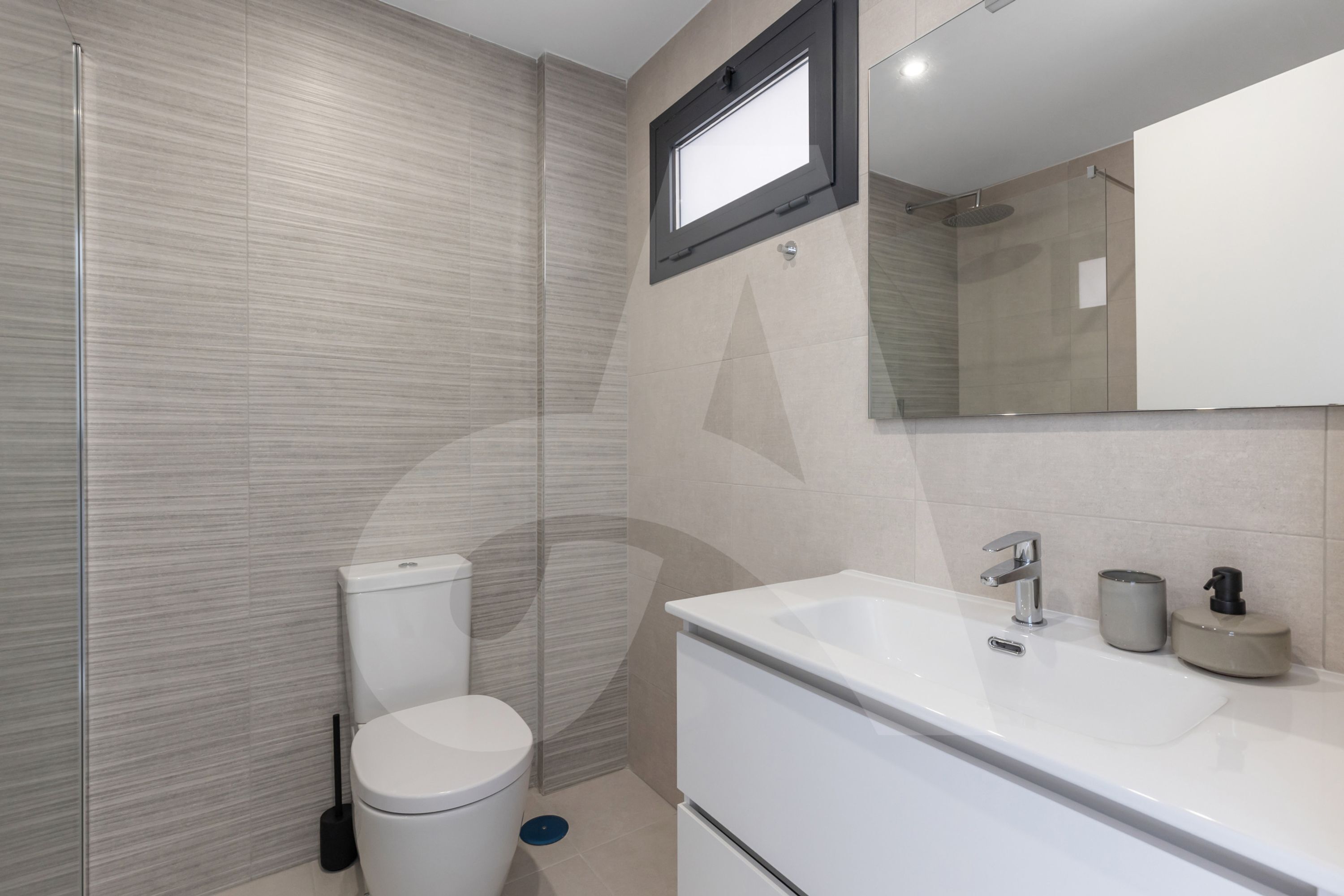 A modern bathroom with a toilet, sink, and shower.