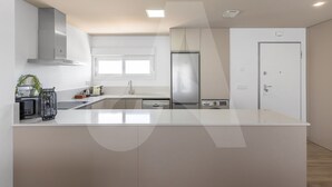 A modern kitchen with a large island, stainless steel appliances, and a window providing natural light. - Casa de Lipa in Orihuela Costa (Orihuela)