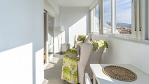 Un balcon avec une table, des chaises et une vue sur la ville.