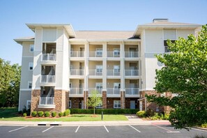 Un immeuble d’appartements à plusieurs étages, doté de balcons, d’un parking et d’une pelouse bien entretenue.