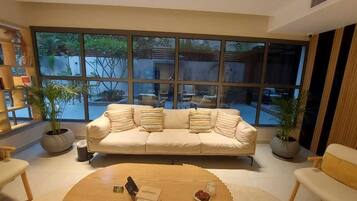 A modern living room with a sofa, coffee table, and potted plants.