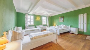 A room with two beds, a desk, a chair, and a radiator. - Vacation in the castle up to 15 pers. Apartment: Burggraf & Himmelsleiter (Großbodungen)